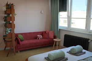 a living room with a red couch and a window at Kwiat Paproci Design Apartment Gdynia in Gdynia