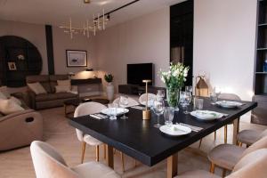 a dining room with a black table and chairs at Amber Sun Towers 11th Floor in Świnoujście