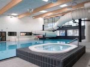 a large swimming pool with a slide in a building at 5 star holiday home in Farsø in Farsø