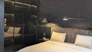 a bedroom with a white bed and a brick wall at 4 Bedroom duplex in Orchid in Lekki +8 photos