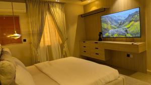 a bedroom with a bed and a flat screen tv at 4 Bedroom duplex in Orchid in Lekki