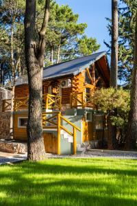 a log cabin with a tree in front of it at Cabañas Mapuche in Mar de las Pampas