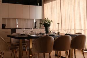 a dining room table with chairs and a vase of flowers at Amber Sun Towers 11th Floor in Świnoujście