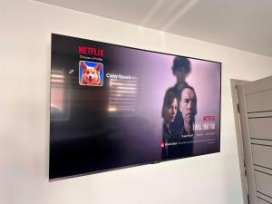 a flat screen tv hanging on a wall at Cozy Spark Studio Apartment in Kelmė