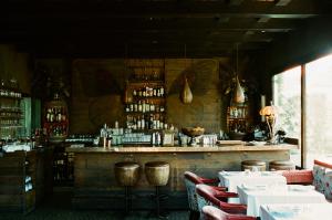 a restaurant with a bar with white tables and chairs at Petit Ermitage in Los Angeles