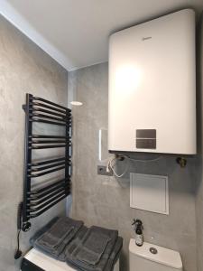 a bathroom with a white cabinet above a toilet at Cozy Spark Studio Apartment in Kelmė +20 photos
