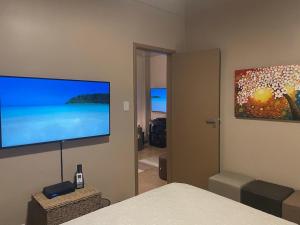 a bedroom with a large flat screen tv on the wall at BeM Ipanema in Rio de Janeiro