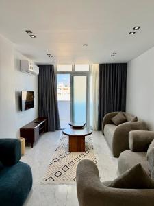 a living room with two couches and a table at Retaj Waterfront Penthouse in Port Said