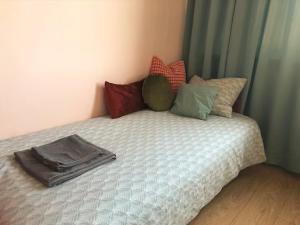 a bed with colorful pillows on it in a room at Kwiat Paproci Design Apartment Gdynia in Gdynia