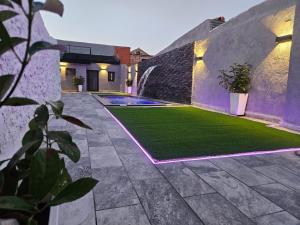 a backyard with a lawn and a swimming pool at La Casa Los Patios in Mahora