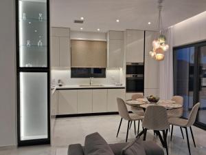 a kitchen and dining room with a table and chairs at Villa Rinoula-private pool in Vitalades
