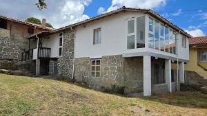 a white house with a stone wall at Mirada Sacra in Parada del Sil