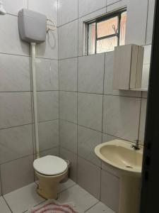 a bathroom with a toilet and a sink at Casa no centro in Primavera do Leste