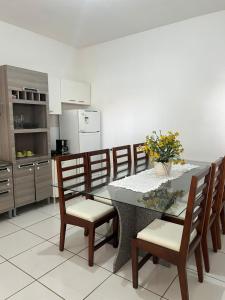a kitchen with a dining table with chairs and a counter at Casa no centro in Primavera do Leste