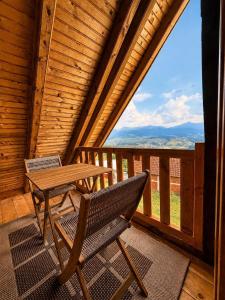 a wooden porch with a table and a bench on a balcony at Grahovo Mountain Chalet in Grahovo