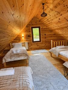 a bedroom with two beds in a wooden cabin at Grahovo Mountain Chalet in Grahovo
