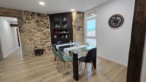 a dining room with a glass table and chairs at Mirada Sacra in Parada del Sil