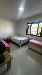 a room with two beds and a window at Canto dos pássaros in Tramandaí