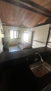 a kitchen with a sink and a bed in a room at Canto dos pássaros in Tramandaí +41 photos