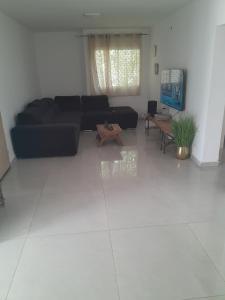 a living room with a black couch and a table at הבית של רוית in Qasrîne