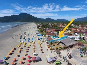 an aerial view of a beach with chairs and umbrellas at peruibe pousada na areia in Peruíbe