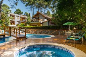 a swimming pool with a table and an umbrella at Cabañas Mapuche in Mar de las Pampas