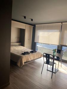a bedroom with a bed and a table and a chair at Edificio Pantera - monoambiente 18 in San Martín de los Andes