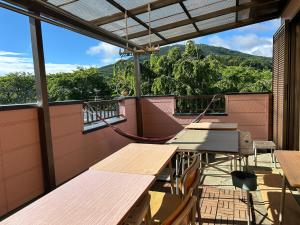 a room with tables and a hammock on a balcony at 民宿とまとハウスTomato House in Funehiki