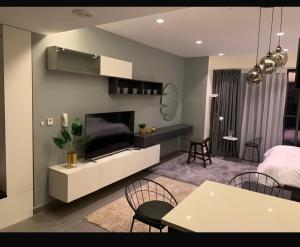 a living room with a television and a living room with a table at Amman studio Damac Tower in Amman +4 photos