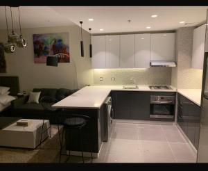 a kitchen with a counter top and a living room at Amman studio Damac Tower in Amman