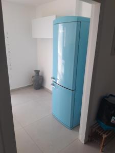 a blue refrigerator in the corner of a room at הבית של רוית in Qasrîne
