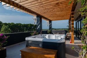 a hot tub on a deck with a pergola at HH Point Luxury Villas in Durrës