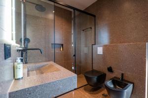 a bathroom with a black toilet and a sink at HH Point Luxury Villas in Durrës