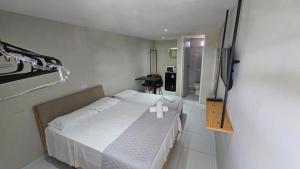 a bedroom with a bed with a stuffed animal on it at Pousada BOB Suítes in Porto De Galinhas