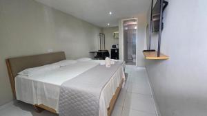 a bedroom with a large bed with a white bedspread at Pousada BOB Suítes in Porto De Galinhas