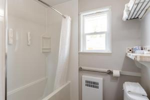 a white bathroom with a shower and a window at 2400 Motel in Vancouver +37 photos
