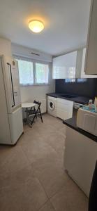 a kitchen with a refrigerator and a table in it at 10 mn Paris in Gennevilliers