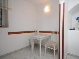 a small white table and two chairs in a room at Apartments and rooms by the sea Moscenicka Draga, Opatija - 7767 in Mošćenička Draga +14 photos