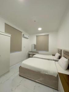 a bedroom with two beds and a projection screen at شقق سكنية مريحة in Tanomah