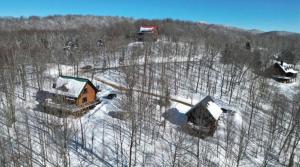 an aerial view of a group of houses in the snow at Le Bois Dormant - Spa, Fireplace, Pool, Lake, Tennis in Lac-Superieur +49 photos