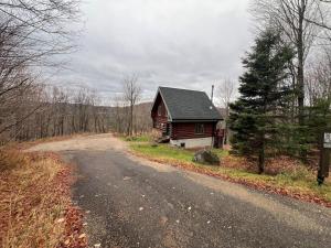 a house on the side of a road at Le Bois Dormant - Spa, Fireplace, Pool, Lake, Tennis in Lac-Superieur