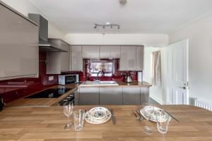 a kitchen with a wooden table with wine glasses on it at The Bothy in Dundee