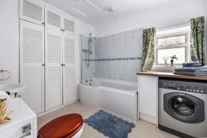 a bathroom with a tub and a washing machine at The Bothy in Dundee