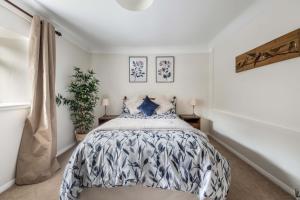 a bedroom with a bed with a blue and white comforter at The Bothy in Dundee