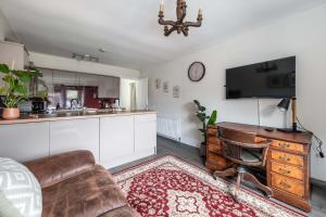 a living room with a couch and a tv and a kitchen at The Bothy in Dundee +13 photos