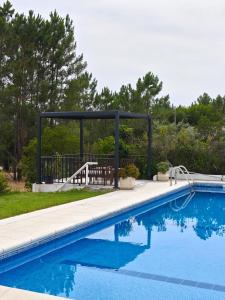 a swimming pool with a gazebo and a bench at Montes da Salvada in Melides