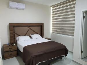 a bedroom with a large bed and a window at Casa de la Playa in Playa Azul
