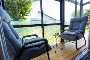 a screened in porch with two chairs and a table at 暮泊くらはく 1日 1組様限定 5名様まで宿泊可能 in Mikasa