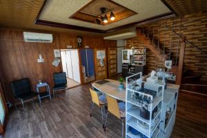 a living room with a table and chairs and a staircase at 暮泊くらはく 1日 1組様限定 5名様まで宿泊可能 in Mikasa