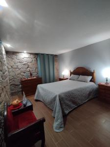 a bedroom with a large bed and a stone wall at Casa da Aldeia in Santa Cruz do Douro